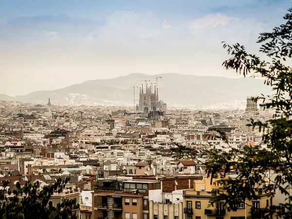 The city of Barcelona from afar. The prominent and recognisable landmark La Sagrada Familia towers above the city.
