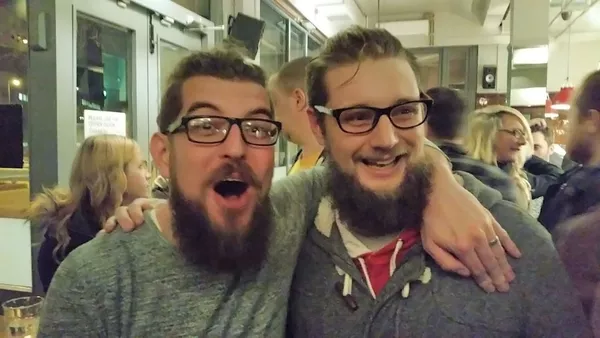 Bart Feenstra and Darren Fisher - two young men with long hair, thick glasses and long beards (who look very similar) at the Saturday night party for DrupalCamp 2016.