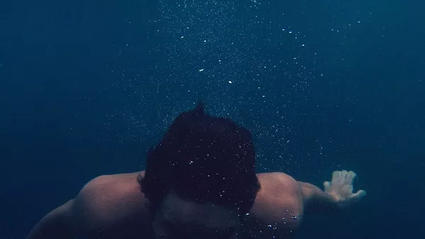 A man immersed in very deep water without breathing equipment.