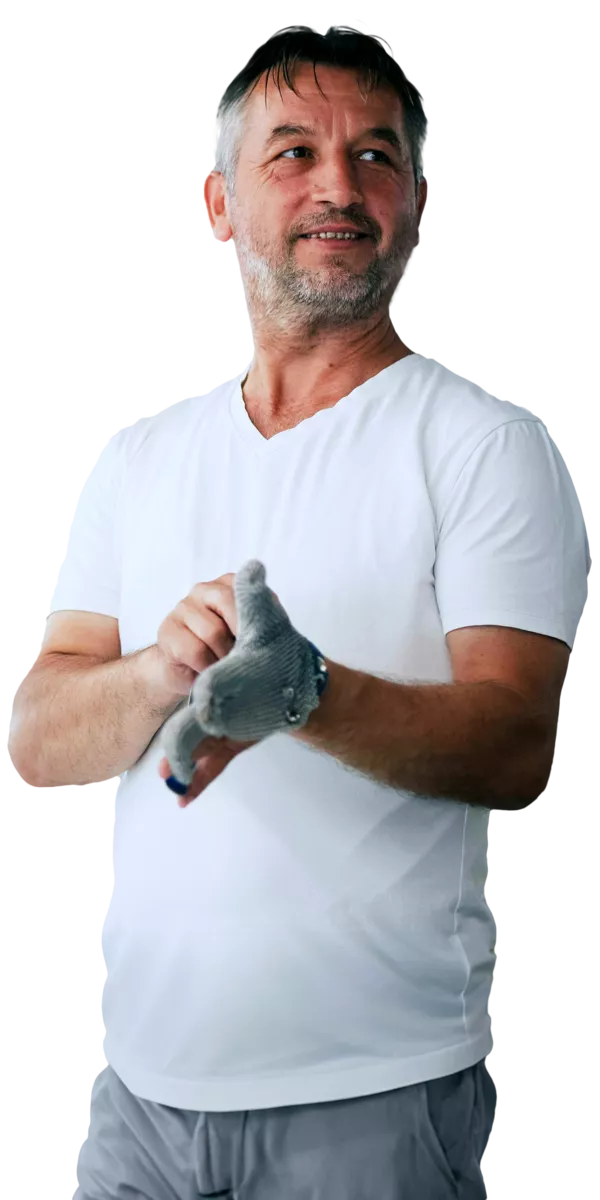 A friendly man smiling as he removes his gloves.