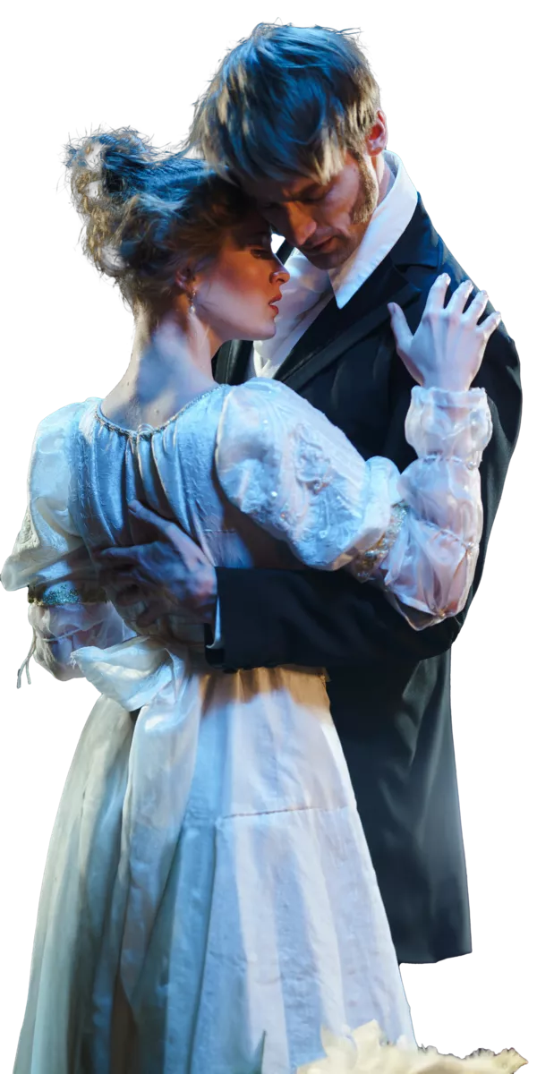 A male and female actor embrace on stage.