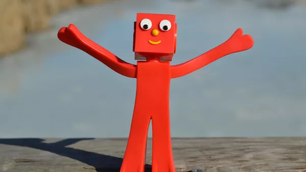 A red robot celebrating with it&apos;s arms in the air.