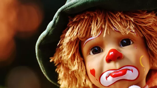 A sad looking clown doll.