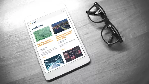 The blog page shown on an Apple iPad which is laid on a desk next to a pair of reading glasses.