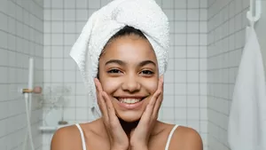A happy smiling woman with her hair in a turban towel.